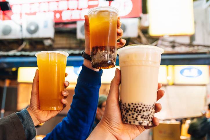 Tourists put Bubble Milk Teas up in the air, street food at Ximending in Taipei, Taiwan.