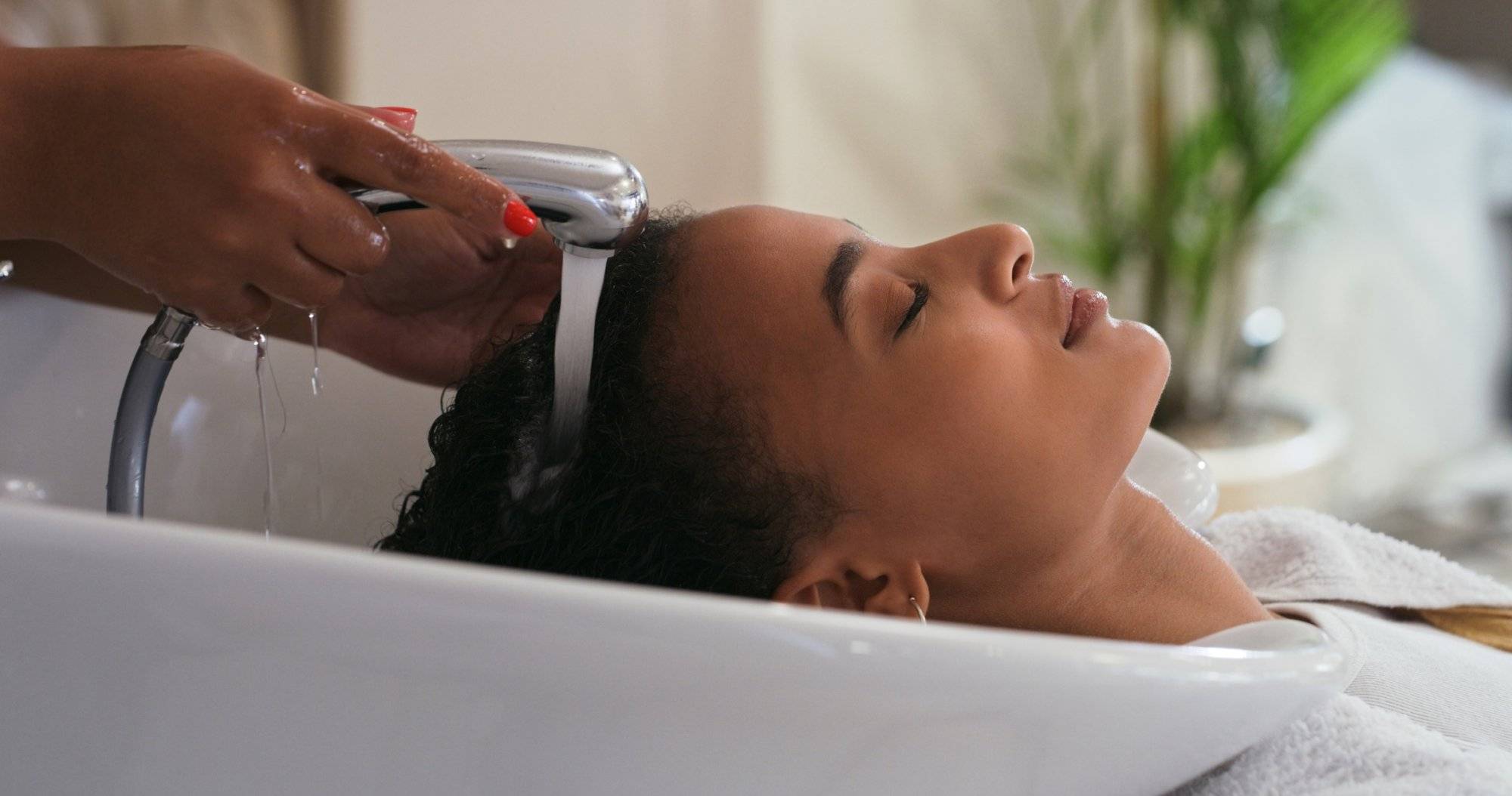 Shot of a young woman getting her hair washed at a salon