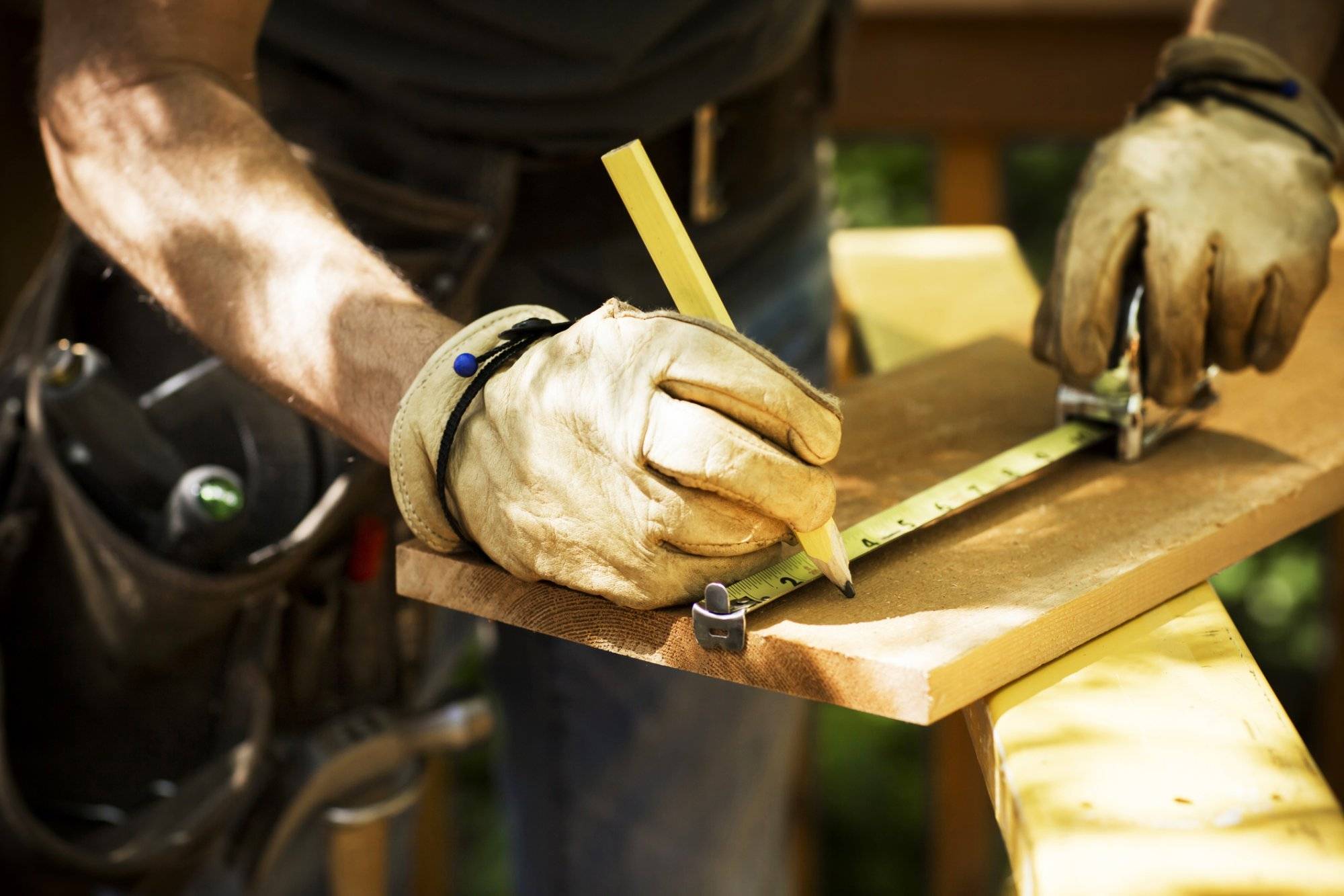 Carpenter Measuring A Wooden Plank. Carpenter Measuring A Wooden Plank.